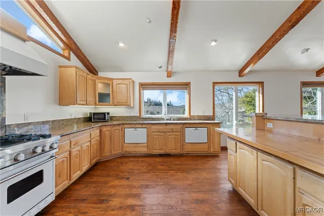 a large kitchen with granite countertop a large window and a sink