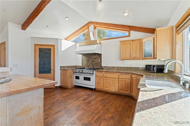 a kitchen with granite countertop white cabinets and white stove