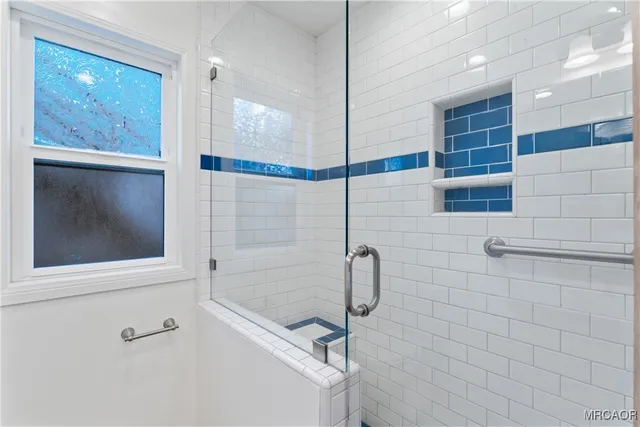 an empty room with wooden floor staircase and windows