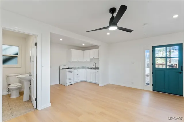 a kitchen with white cabinets and appliances