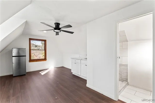 a view of a kitchen with wooden floor and a ceiling fan