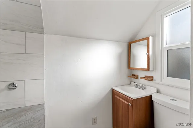 a view of a bedroom with wooden floor and a ceiling fan