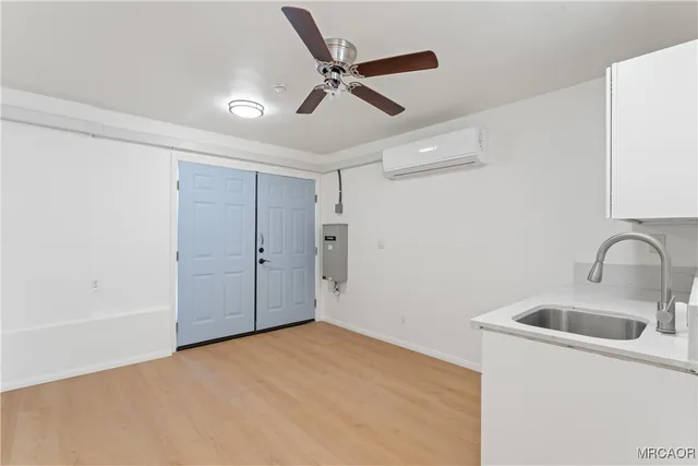 an empty room with a window and a fan