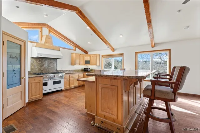 a large kitchen with stainless steel appliances a large counter top and a stove