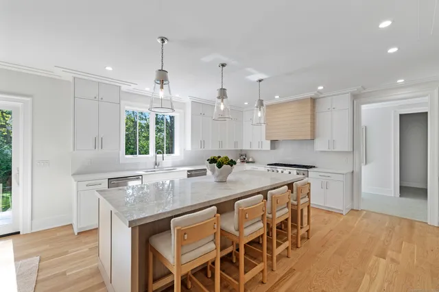a kitchen with kitchen island granite countertop a sink and a refrigerator