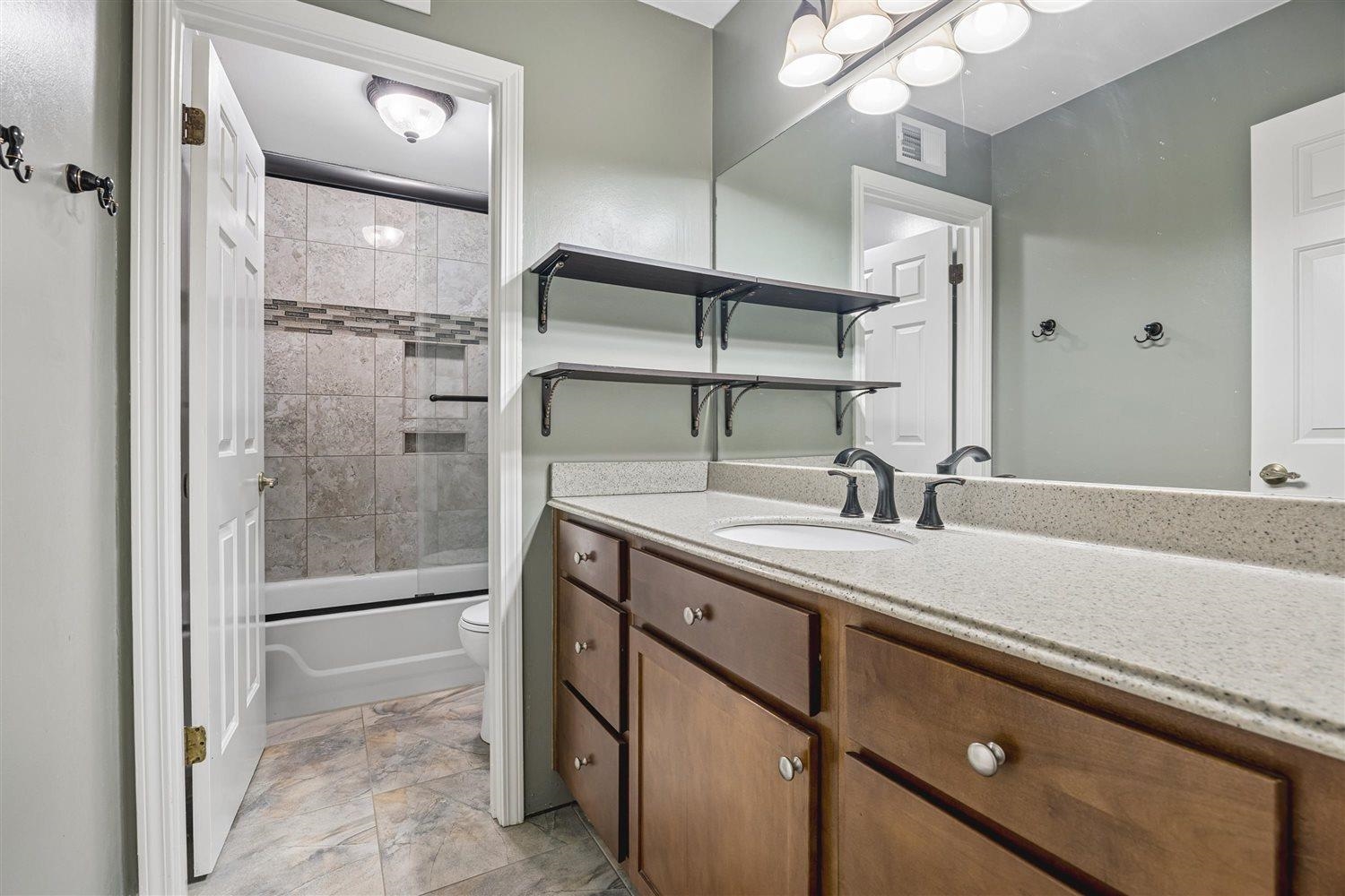 8970 Farmoor Road Germantown, TN 38139 - Photo 20 of 35 Bathroom vanity featuring a light-toned countertop, dual sinks, and wood-finish cabinetry