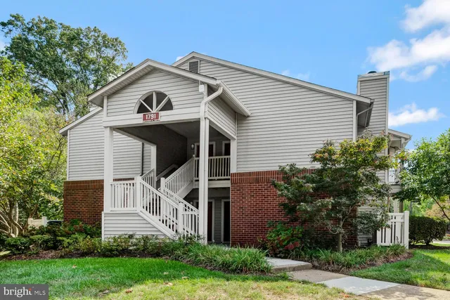 a view of a white house next to a yard