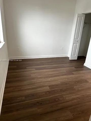 an empty room with wooden floor and closet