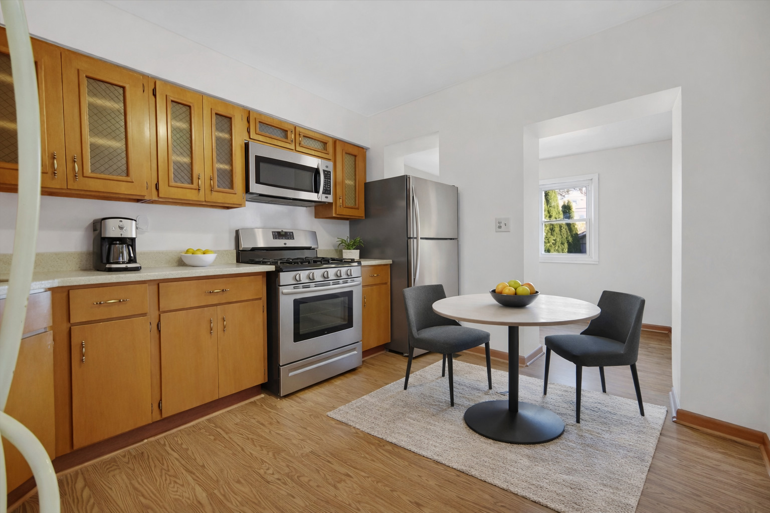 3329 South Racine Avenue Chicago, IL 60608 - Photo 6 of 33 a kitchen with stainless steel appliances kitchen island granite countertop a stove a sink dishwasher and white cabinets with wooden floor