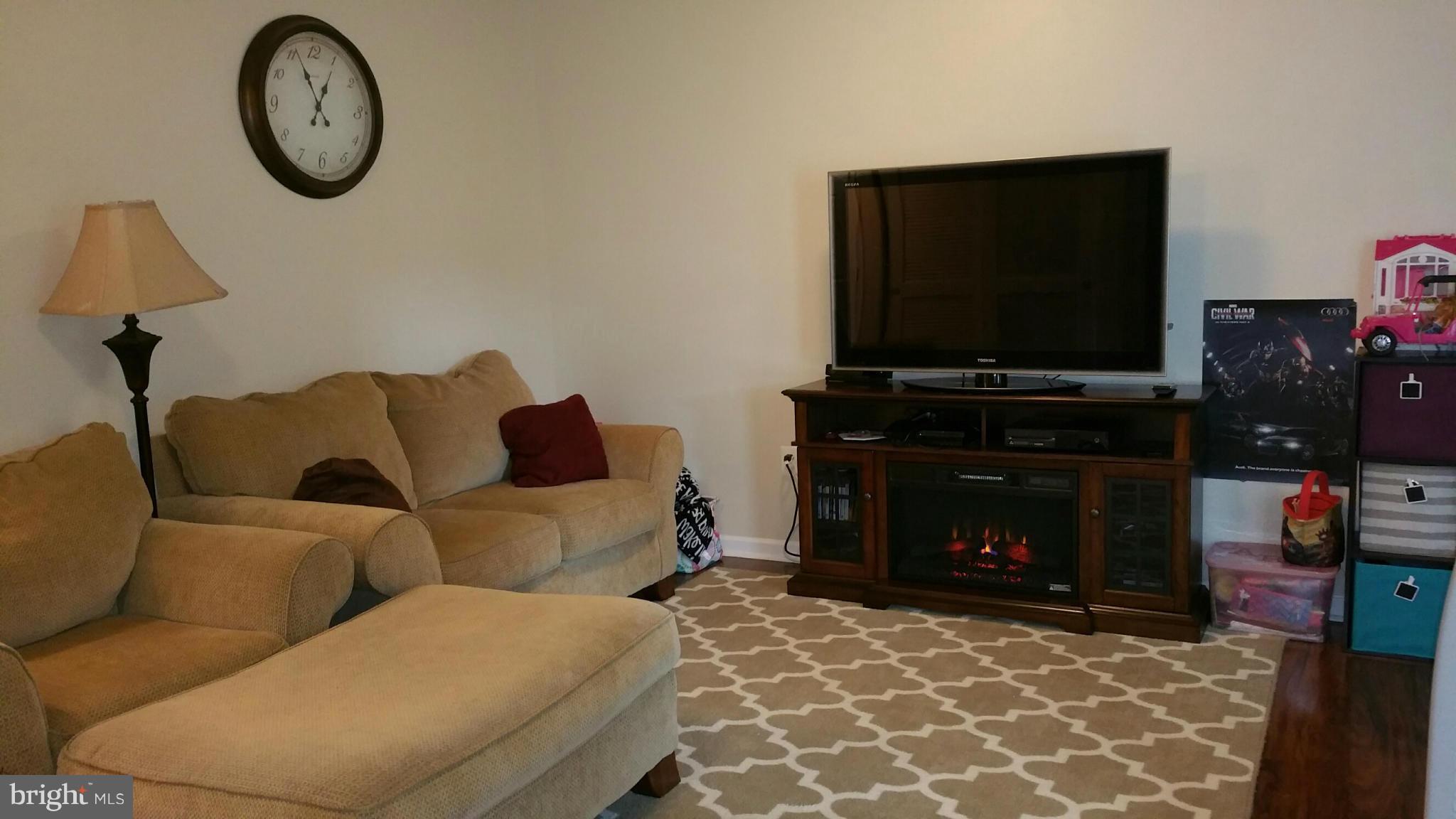 917 Tipton Road Baltimore, MD 21220 - Photo 4 of 24 a living room with furniture a flat screen tv and a fireplace