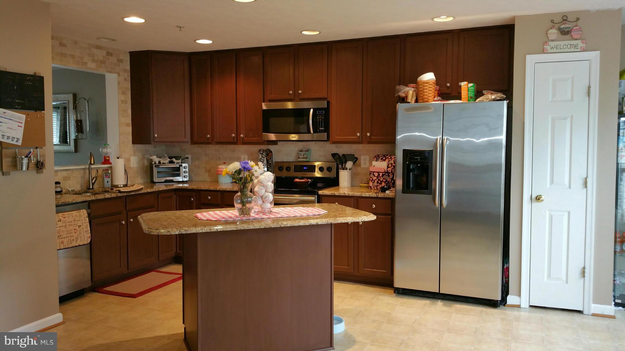 917 Tipton Road Baltimore, MD 21220 - Photo 8 of 24 a kitchen with stainless steel appliances granite countertop a refrigerator a sink a stove a microwave and a refrigerator