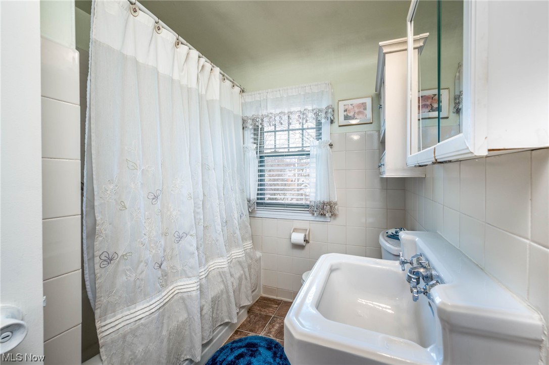 253 Butler Road Northeast Warren, OH 44483 - Photo 26 of 35 Bathroom with tile floors, sink, and tile walls