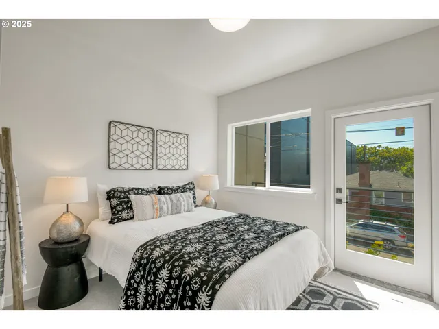 a bedroom with a bed and a large window