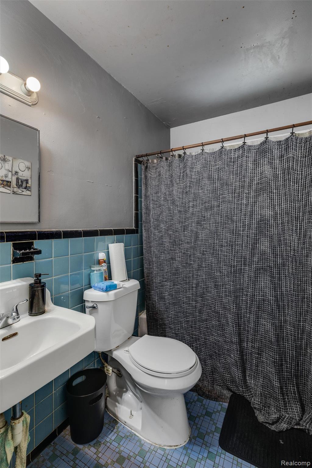 10878 Balfour Road Detroit, MI 48224 - Photo 8 of 14 Full bath featuring tile walls, curtained shower, tile patterned flooring, and a wainscoted wall