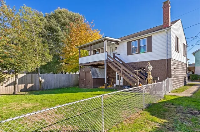 a view of a house with a yard and a wooden fence