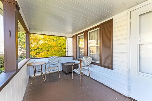 a view of a porch with furniture and wooden floor