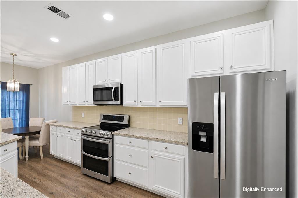 2555 Flat Shoals Road, Unit 2008 Atlanta, GA 30349 - Photo 11 of 33 a kitchen with white cabinets and stainless steel appliances