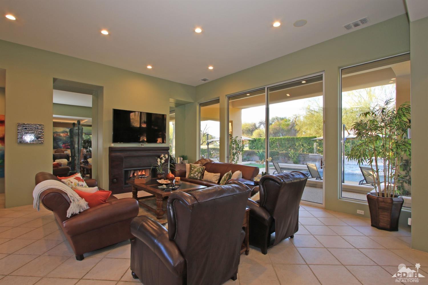 250 Loch Lomond Road Rancho Mirage, CA 92270 - Photo 10 of 33 a living room with furniture a flat screen tv and floor to ceiling window