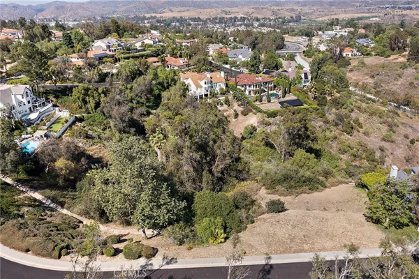 an aerial view of a houses with a lush green hillside