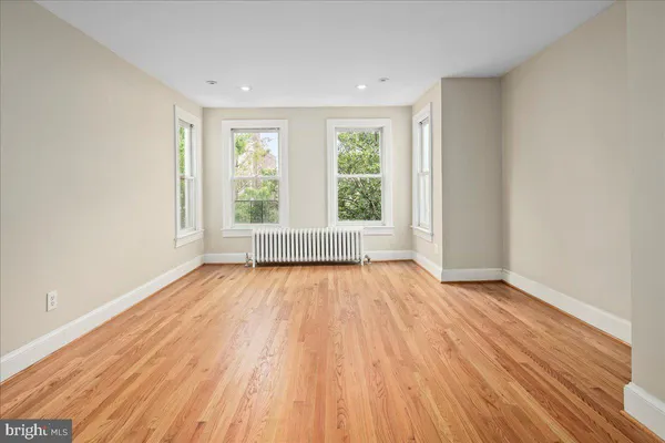 a kitchen with stainless steel appliances granite countertop a refrigerator a stove a sink dishwasher and white cabinets with wooden floor