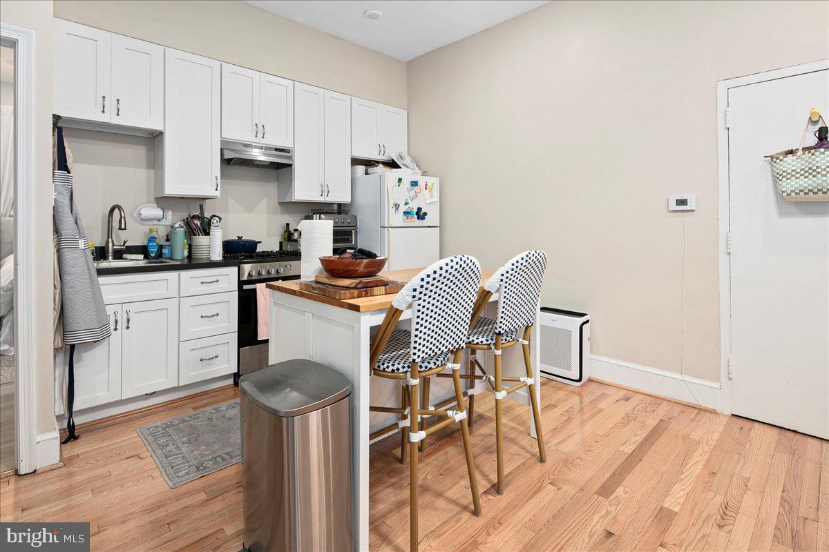 304 2nd Street Southeast Washington, DC 20003 - Photo 59 of 70 a kitchen with stainless steel appliances a stove a sink dishwasher and cabinets with wooden floor