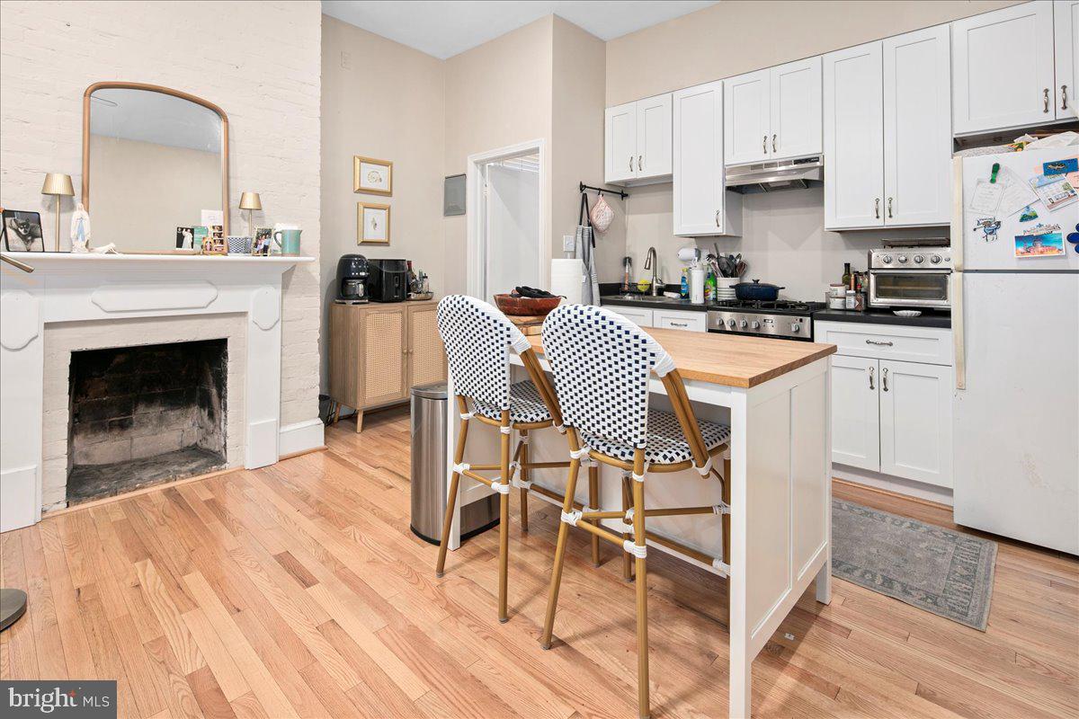 304 2nd Street Southeast Washington, DC 20003 - Photo 61 of 70 a kitchen with stainless steel appliances a stove a sink dishwasher and white cabinets with wooden floor