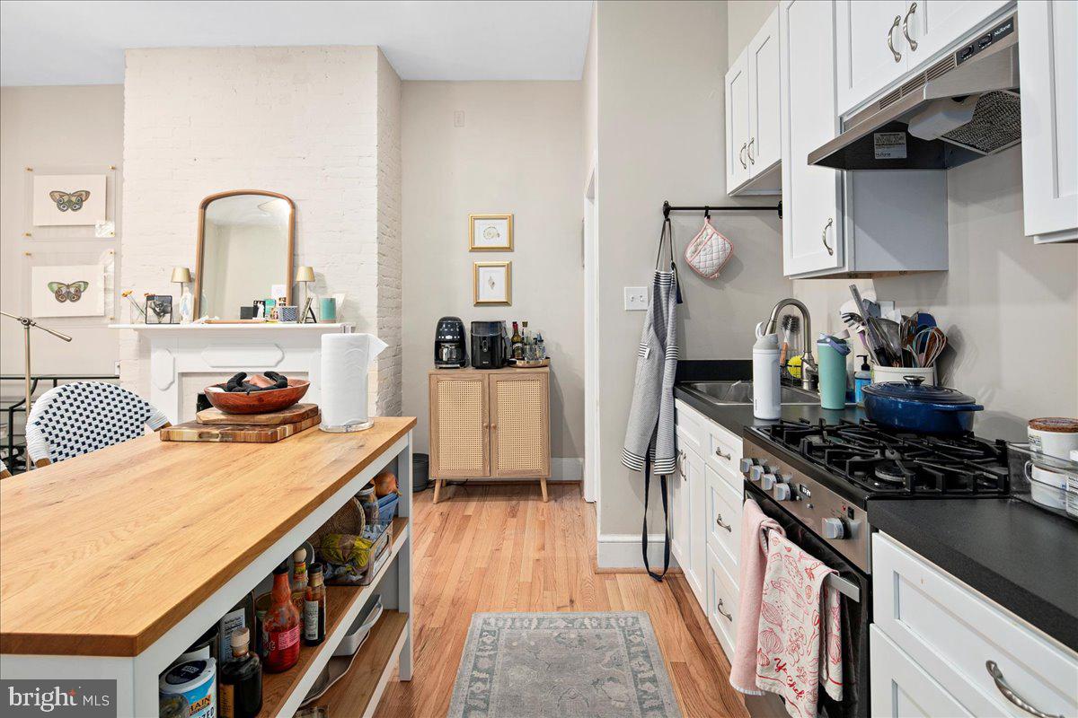 304 2nd Street Southeast Washington, DC 20003 - Photo 63 of 70 a kitchen with stainless steel appliances a stove a sink dishwasher and cabinets with wooden floor