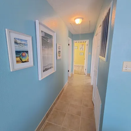 a view of hallway with window and a refrigerator
