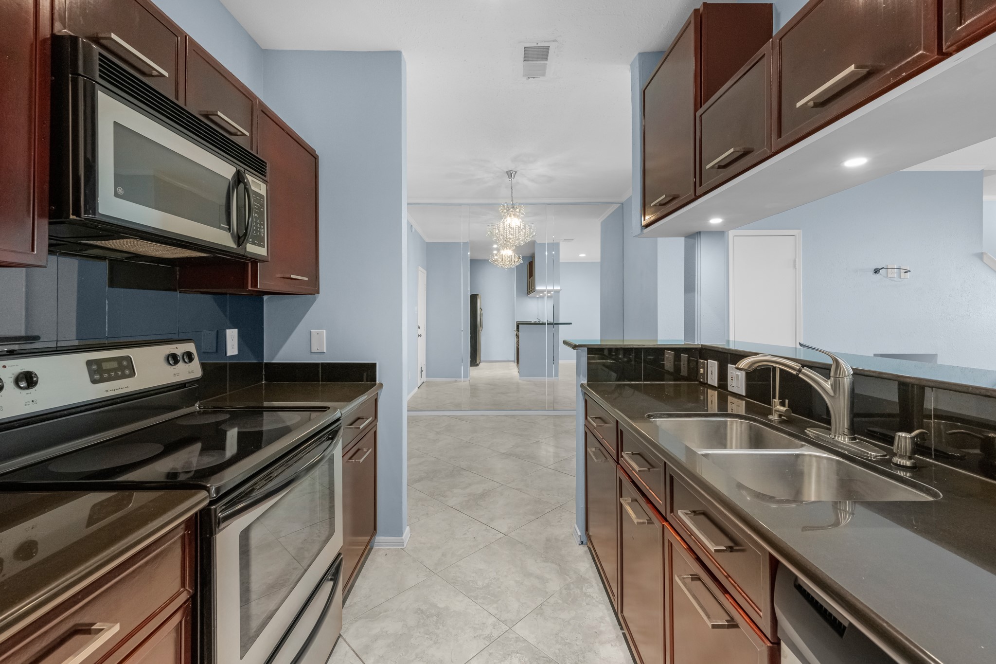 a kitchen with stainless steel appliances granite countertop a sink a stove microwave and refrigerator