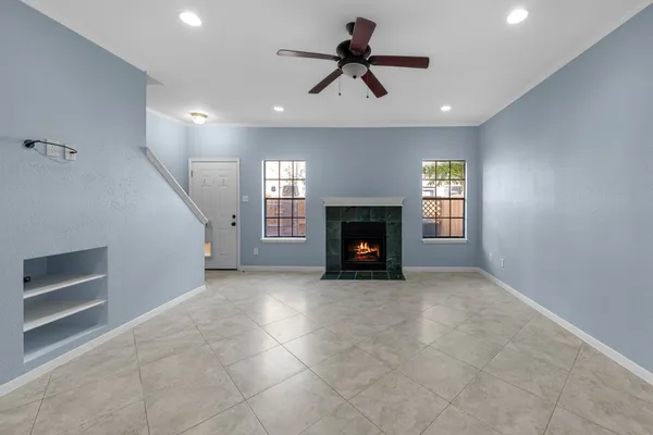 a view of empty room with a fireplace and windows