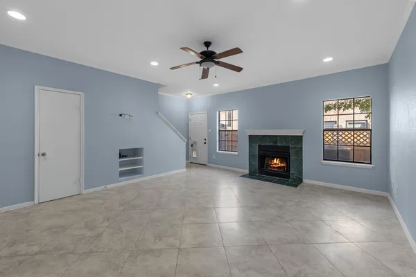 a view of an empty room with a fireplace and a window