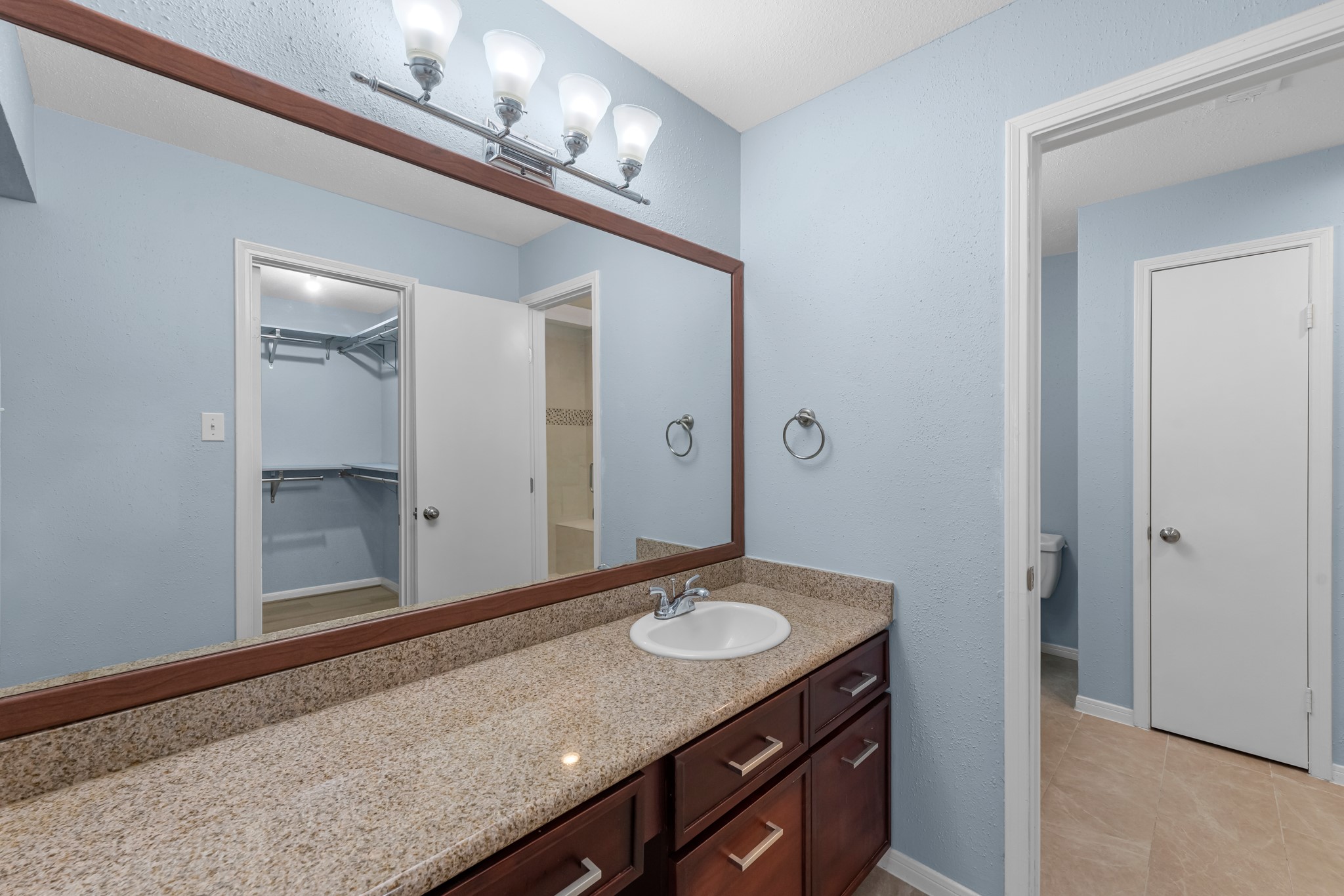 9800 Pagewood Lane, Unit 3103 Houston, TX 77063 - Photo 17 of 27 a bathroom with a granite countertop sink a mirror and a shower