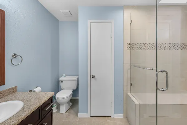 a bathroom with a granite countertop sink toilet and shower