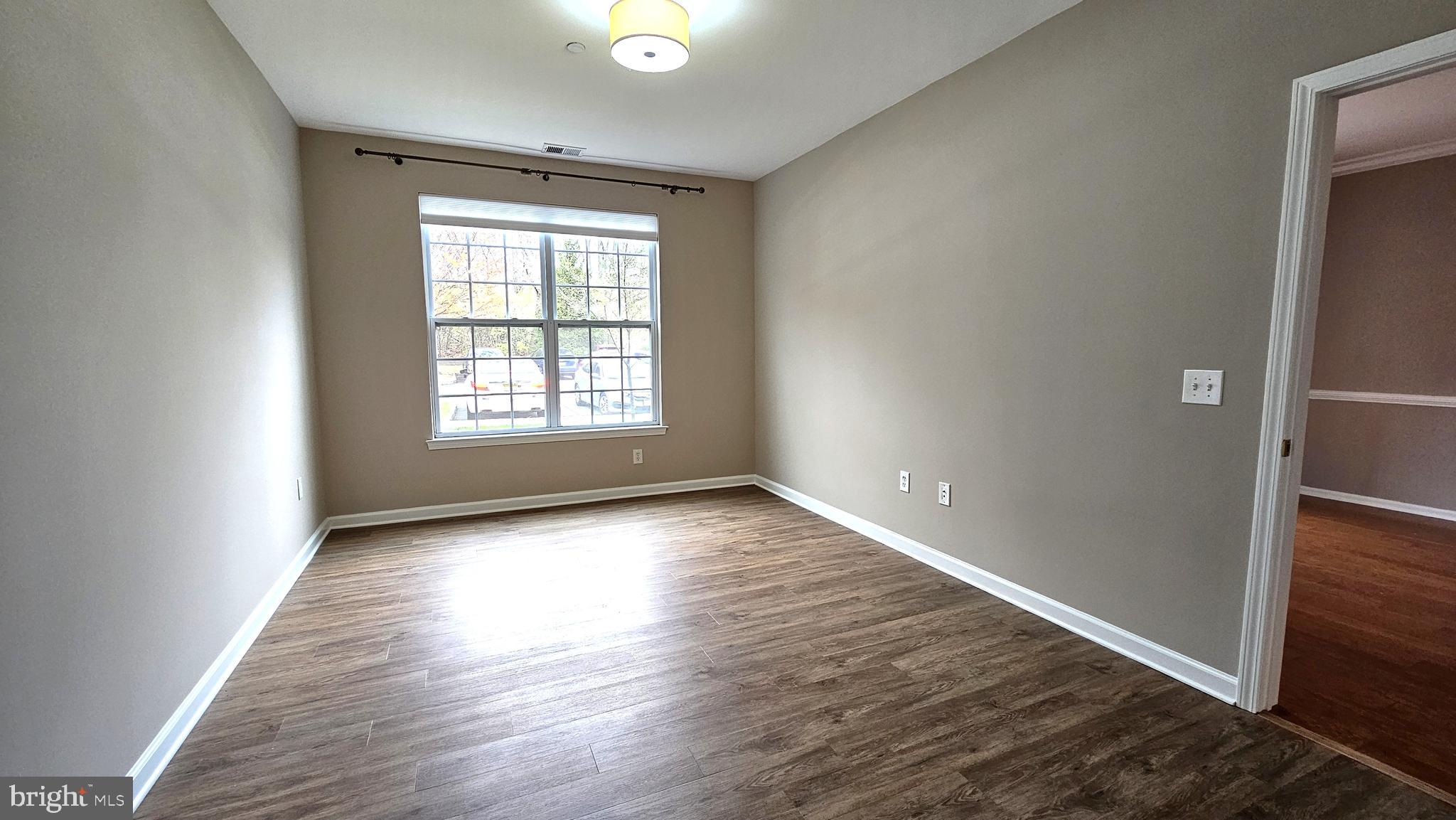 1121 Colts Circle, Unit P Lawrenceville, NJ 08648 - Photo 13 of 34 an empty room with wooden floor and windows