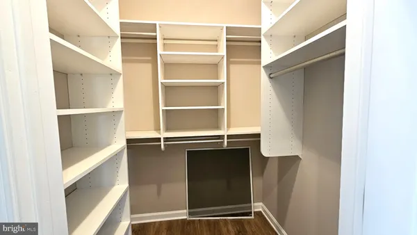 a view of walk in closet with empty racks