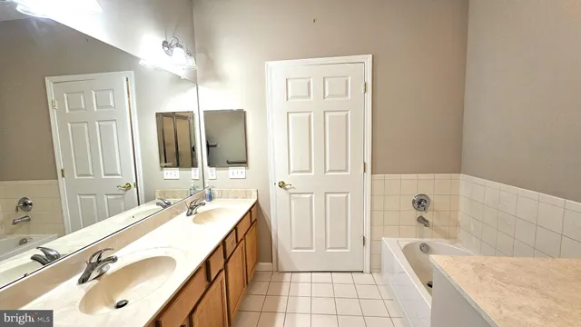 a spacious bathroom with a tub sink and mirror