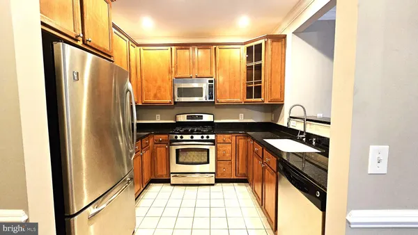 a kitchen with stainless steel appliances granite countertop a refrigerator and a stove