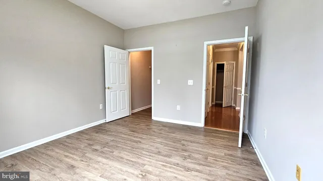 an empty room with wooden floor and closet