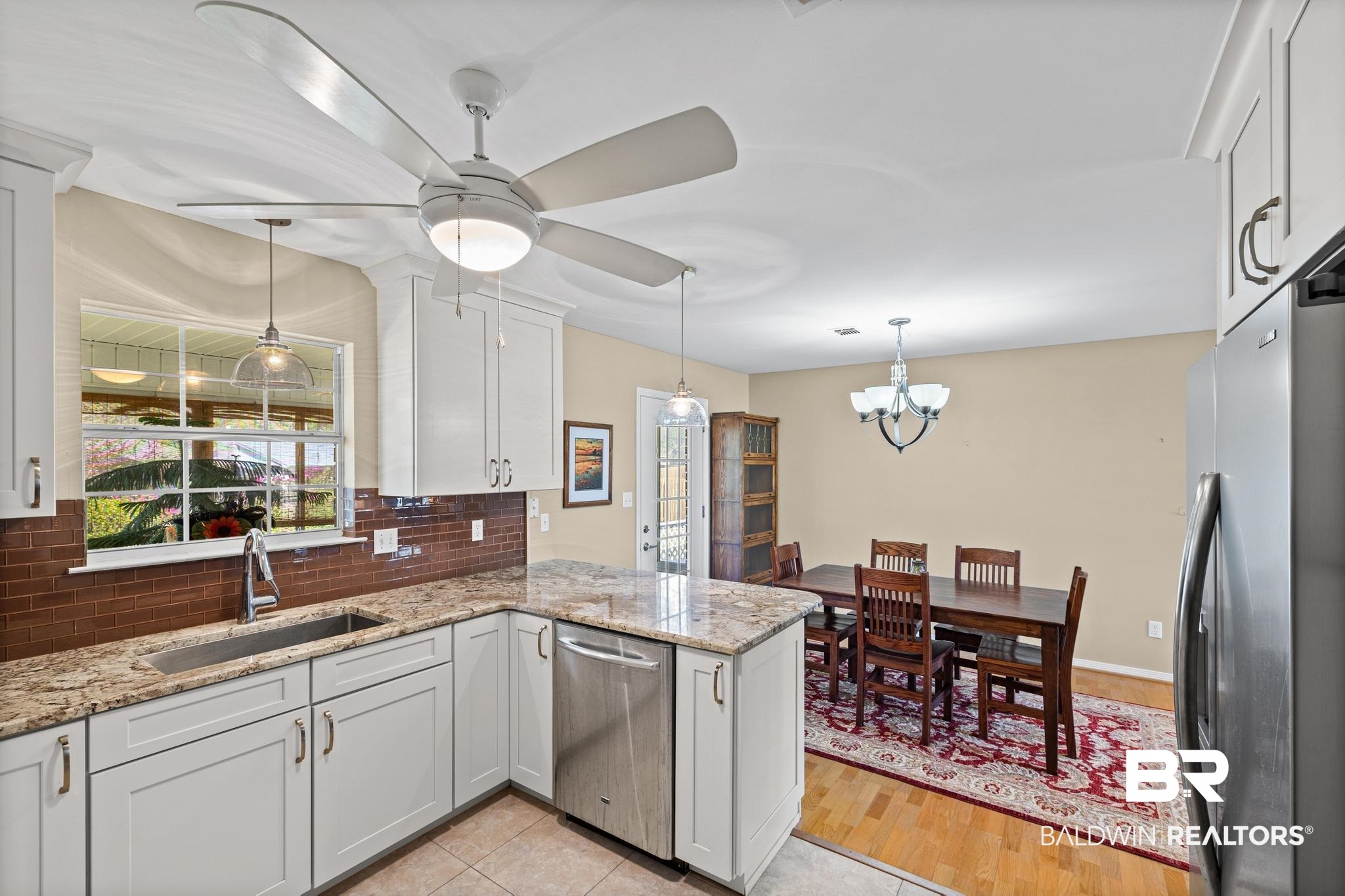 2881 Eslava Circle Lillian, AL 36549 - Photo 9 of 58 Kitchen with stainless steel appliances, light stone countertops, a ceiling fan, backsplash, and white cabinets