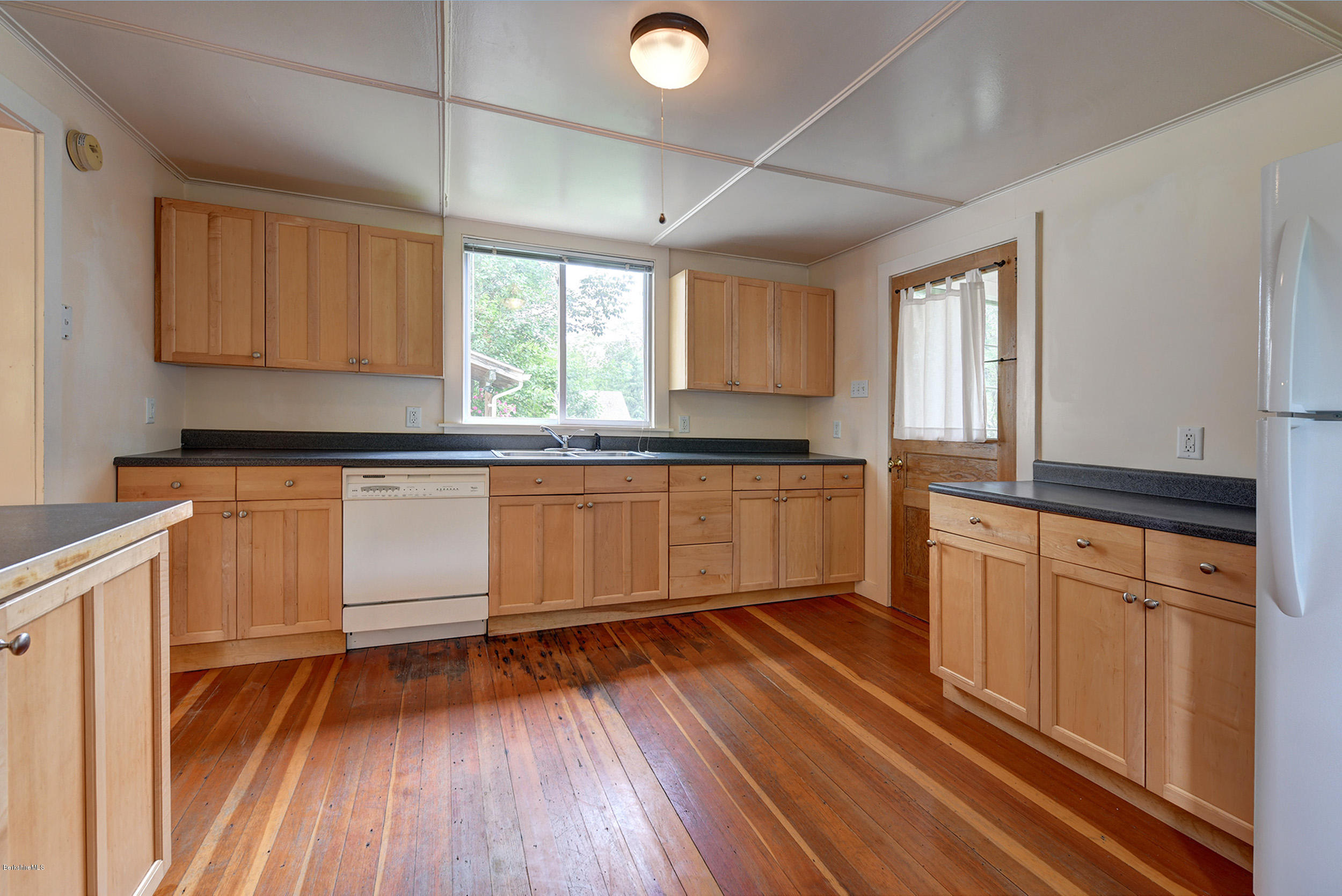 23 Glendale Road Stockbridge, MA 01262 - Photo 12 of 30 a kitchen with wooden floors and white appliances
