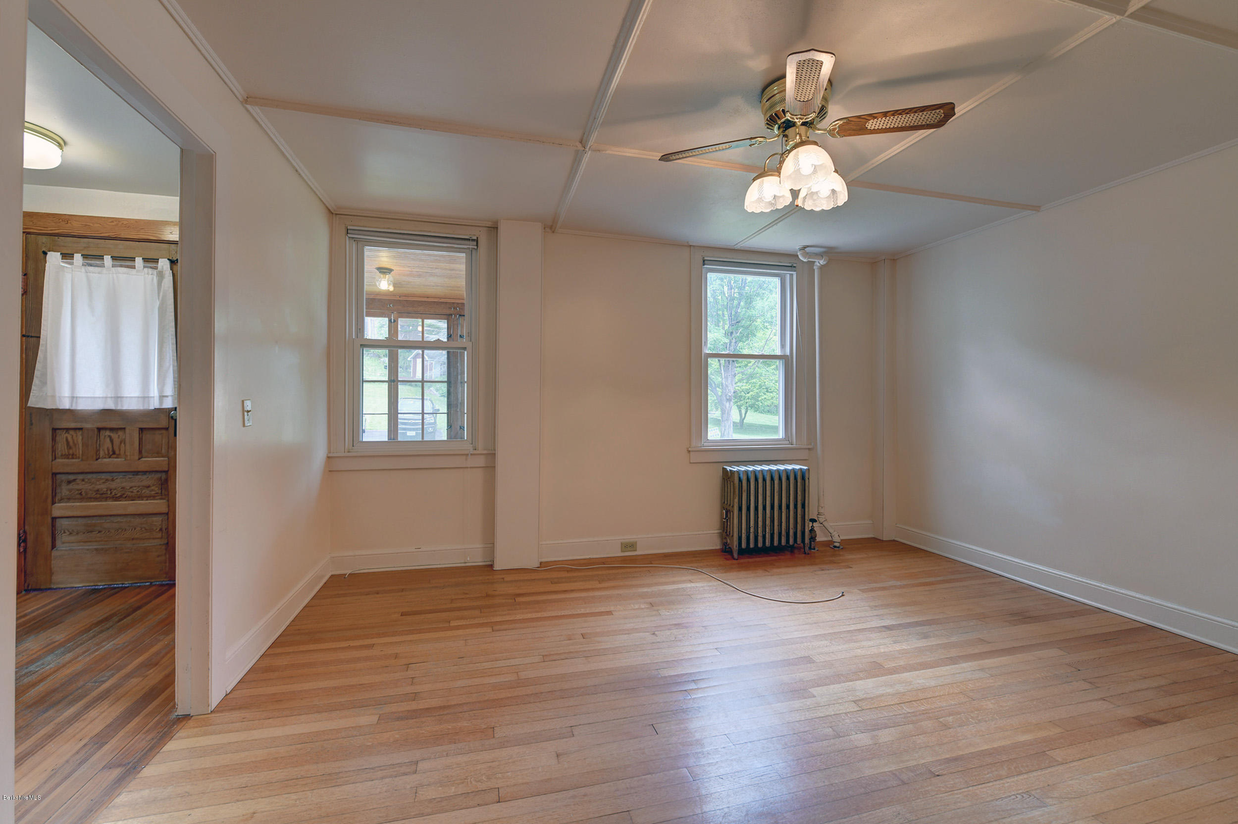 23 Glendale Road Stockbridge, MA 01262 - Photo 7 of 30 an empty room with wooden floor chandelier and windows