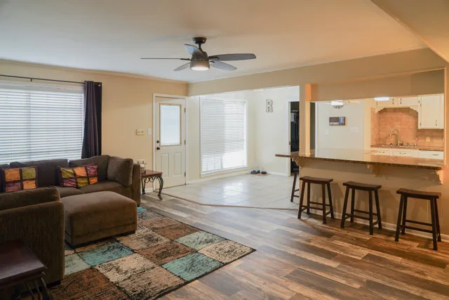 a living room with furniture and a wooden floor