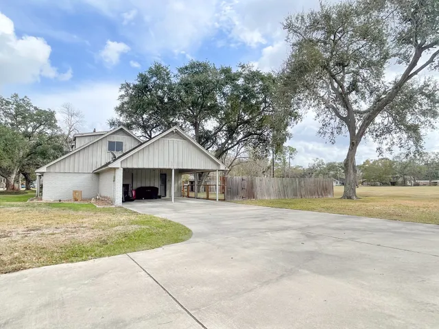 a white house with a large tree in front of it