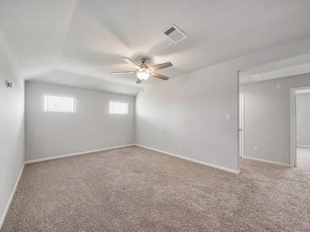 a view of an empty room with a chandelier fan