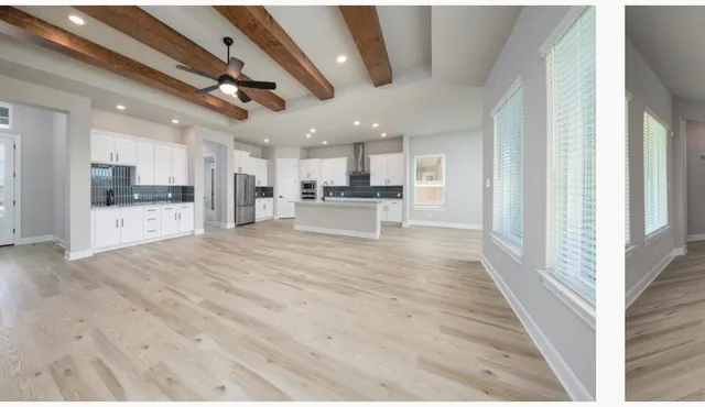 a view of a living room kitchen with stainless steel appliances wooden floor and large windows