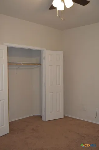 an empty room with a chandelier fan