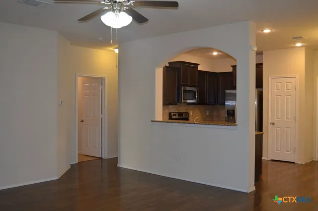 a view of a hallway with a chandelier fan and wooden floor