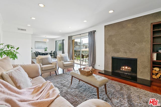 a living room with furniture a fireplace and a floor to ceiling window