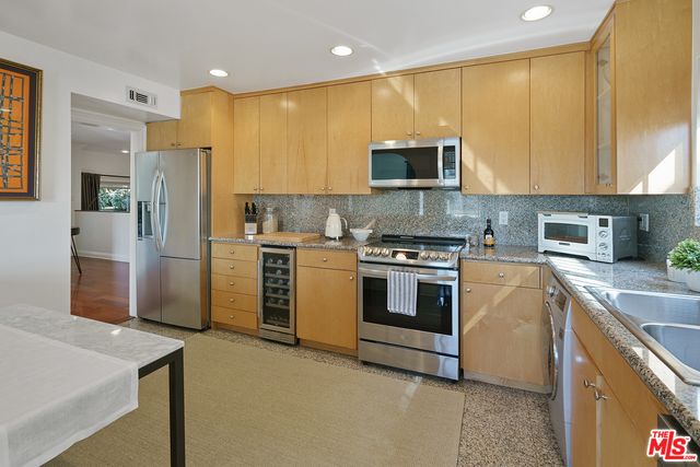 a kitchen with a sink a counter top space stainless steel appliances and cabinets