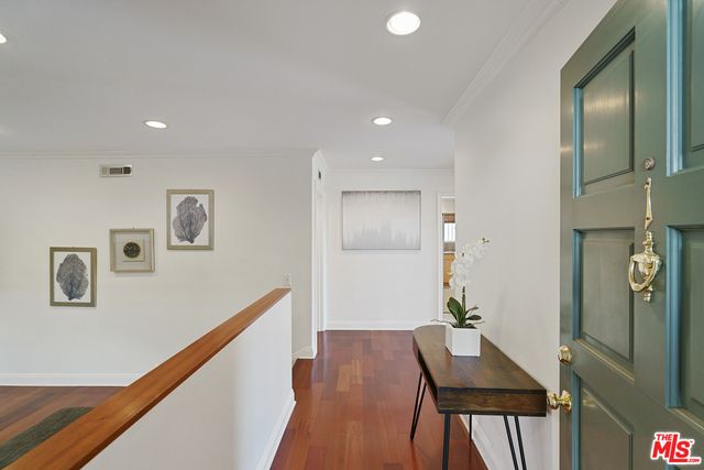 a view of a hallway with furniture and wooden floor